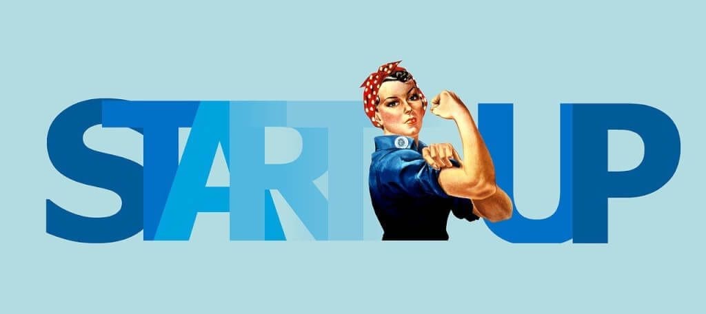 Woman flexing her muscles with the word "startup" behind her.